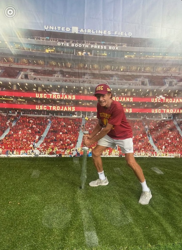 Dr. Marshall Hubsher placing a sword at the 50-yard line before a USC football game